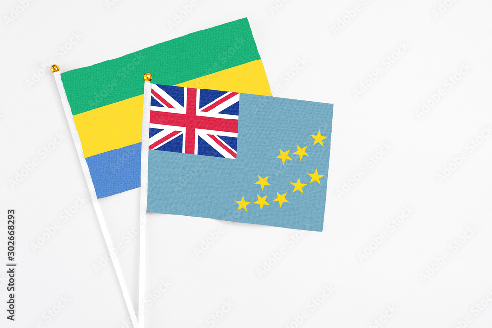 Tuvalu and Gabon stick flags on white background. High quality fabric, miniature national flag. Peaceful global concept.White floor for copy space. Tuvalu and Gabon stick flags on white background. High quality fabric, miniature national flag. Peaceful global concept.White floor for copy space.