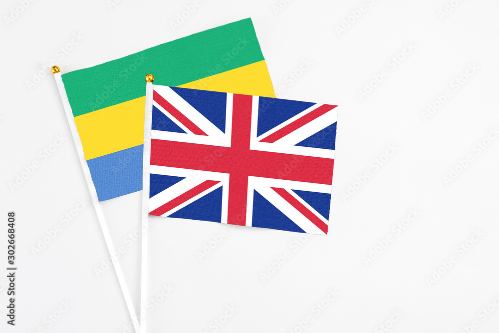 United Kingdom and Gabon stick flags on white background. High quality fabric, miniature national flag. Peaceful global concept.White floor for copy space. United Kingdom and Gabon stick flags on white background. High quality fabric, miniature national flag. Peaceful global concept.White floor for copy space.