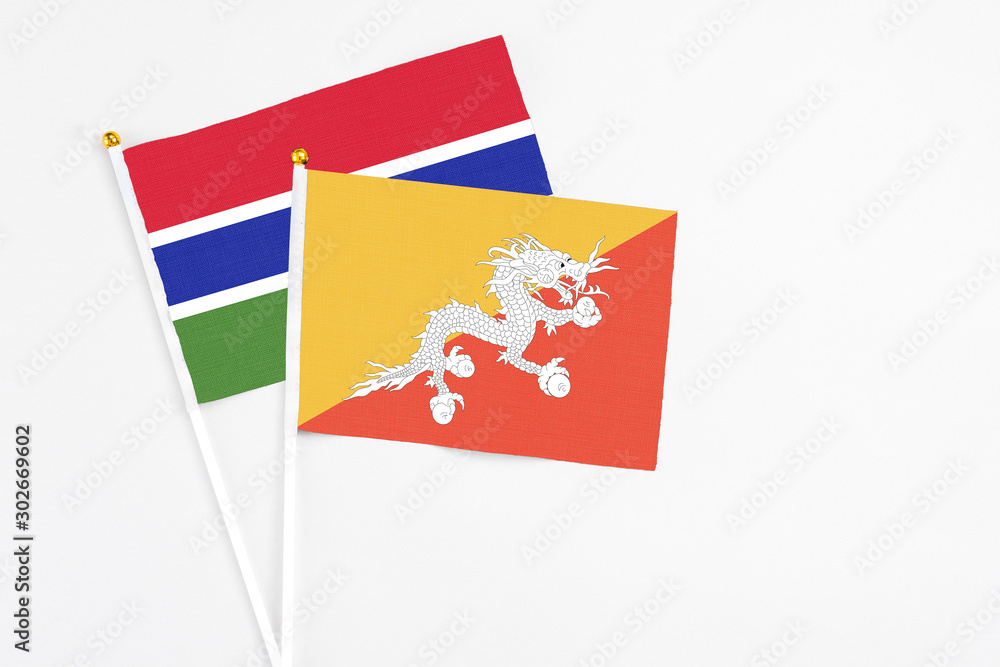 Naklejka premium Bhutan and Georgia stick flags on white background. High quality fabric, miniature national flag. Peaceful global concept.White floor for copy space.