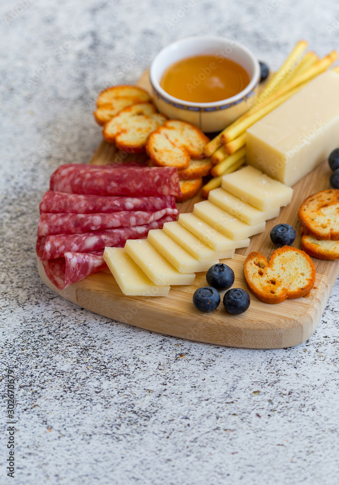 Delicious cheese served with berries, crackers and salami Delicious cheese served with berries, crackers and salami
