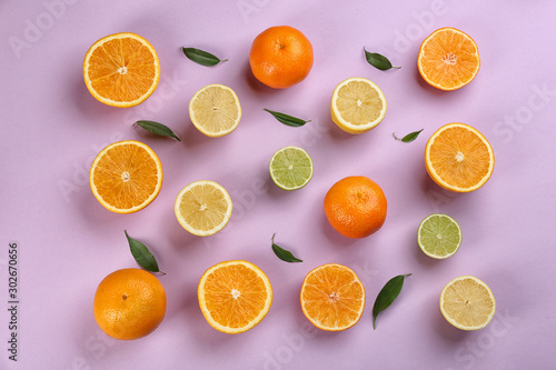 Flat lay composition with tangerines and different citrus fruits on lilac background