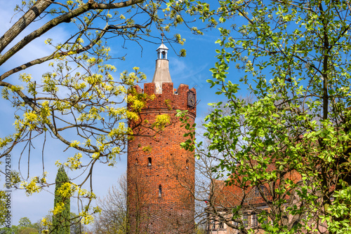 Poland, Guben, Gubin: Old brick Tower (Werderturm or Wieza Bramy Ostrowskiej) in the city center of the small town near German Polish border with green trees and blue sky - travel history architecture
