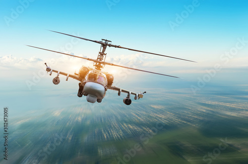Obraz na plátně Combat military helicopter with weapons flies over the city.