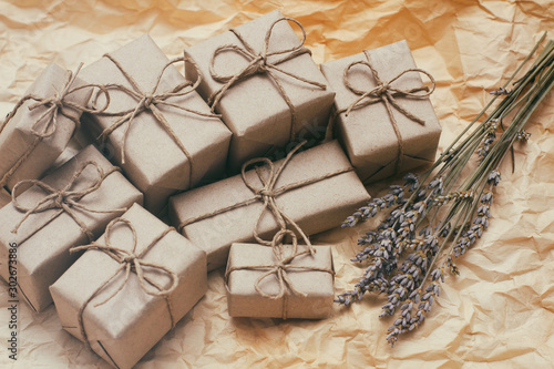 Set of brown gift boxes. Wrapped in craft paper and tied by hemp cord. Old paper background. Small lavender bouquet.	