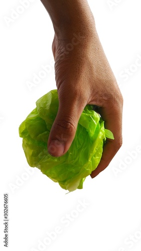 A green plastic bag that is falling from the hand Stop using plastic bags to reduce global warming.