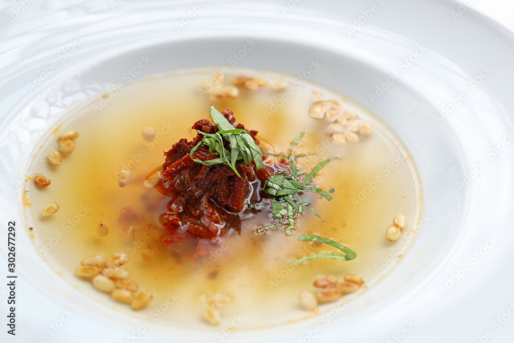 Transparent tomato soup with the addition of dried tomatoes and roasted pine nuts. Transparent tomato soup with the addition of dried tomatoes and roasted pine nuts.