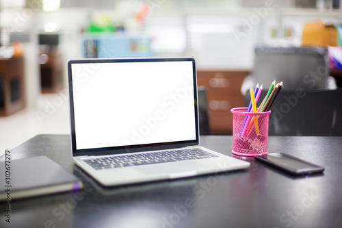 Computer laptop with white blank screen isolated  on work table in office.