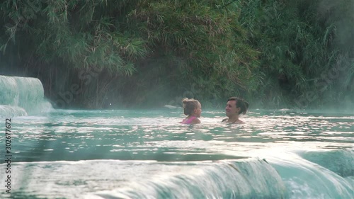Young Mother and Daughter Swimming and Relaxing in Hot Springs of Saturnia, Grosseto, Tuscany, Italy. Natural Spa with Waterfalls and Thermal Waters. Relax and Spa Concept