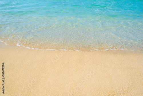 Ocean waves on the beach and blue water in Phuket, Thailand during the high season. Holidays and travel