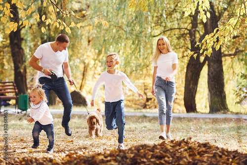 Cheerful young family have a walk in an autumn park together © standret