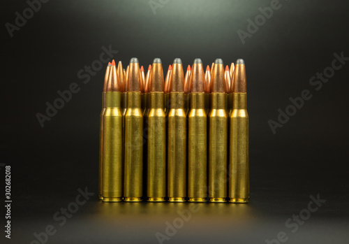 Bullet isolated on black background with reflexion. Rifle bullets close-up on black back. Cartridges for rifle and carbine on a black.Horizontal photo. photo