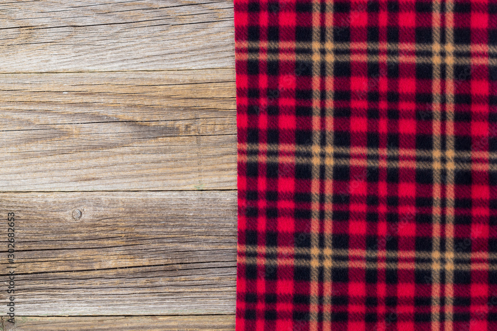background of red plaid and wooden boards. Top view with copyspace background of red plaid and wooden boards. Top view with copyspace