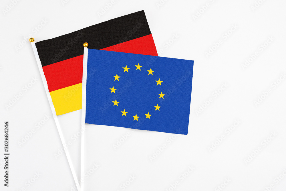 European Union and Germany stick flags on white background. High quality fabric, miniature national flag. Peaceful global concept.White floor for copy space. European Union and Germany stick flags on white background. High quality fabric, miniature national flag. Peaceful global concept.White floor for copy space.