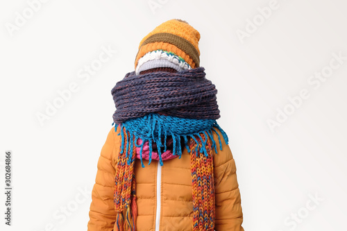 Handsome caucasian funny man hiding face in several hats and scarfs.