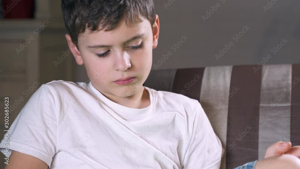 Close up portrait a sad teenager boy who is reading about environmental pollution. Social media and child. Cellphone and device technology. Phone and childhood. Kid and telephone. Cell and gadget. Close up portrait a sad teenager boy who is reading about environmental pollution. Social media and child. Cellphone and device technology. Phone and childhood. Kid and telephone. Cell and gadget.