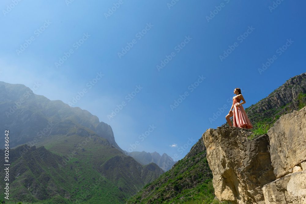 Young hiker freedom fashion woman standing on the top of the big mountains over blue sky background, Mexico.