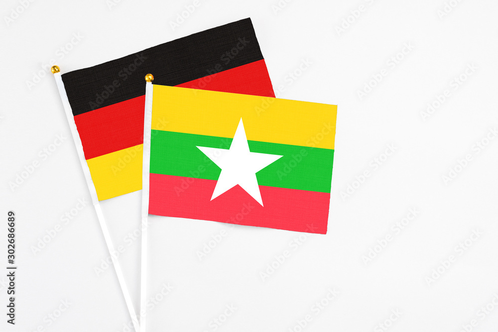 Myanmar and Germany stick flags on white background. High quality fabric, miniature national flag. Peaceful global concept.White floor for copy space.