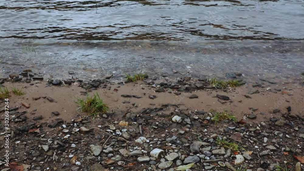 Still shot of river water washing up in waves on shore Still shot of river water washing up in waves on shore
