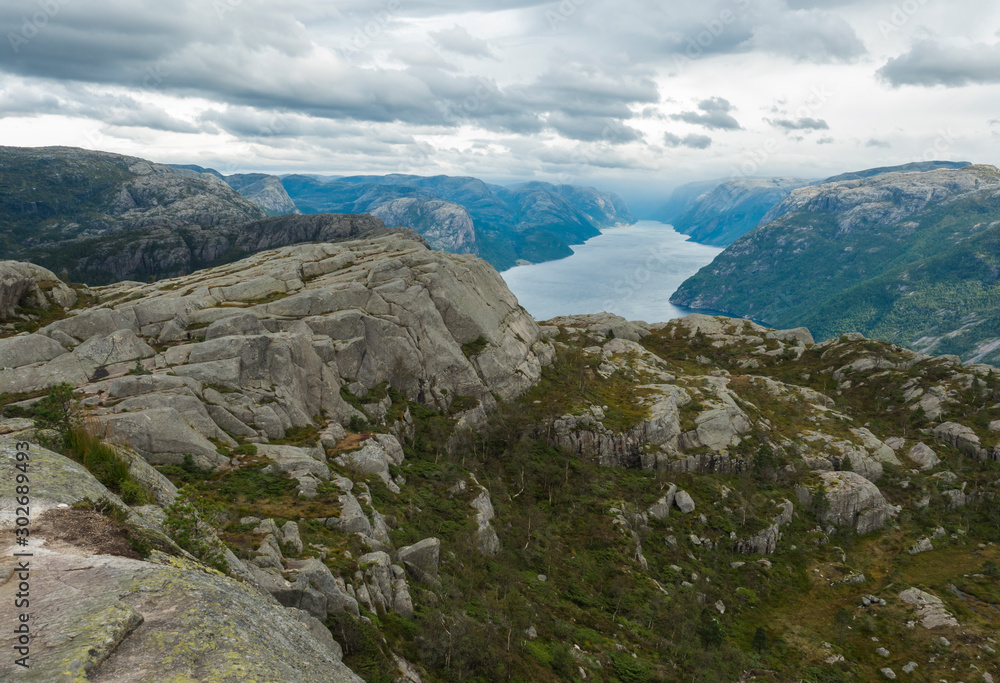 View on fjord Lysefjord, next to Preikestolen massive cliff famous Norway viewpoint Moody sky, autumn day. Nature and travel background, vacation and hiking holiday concept.