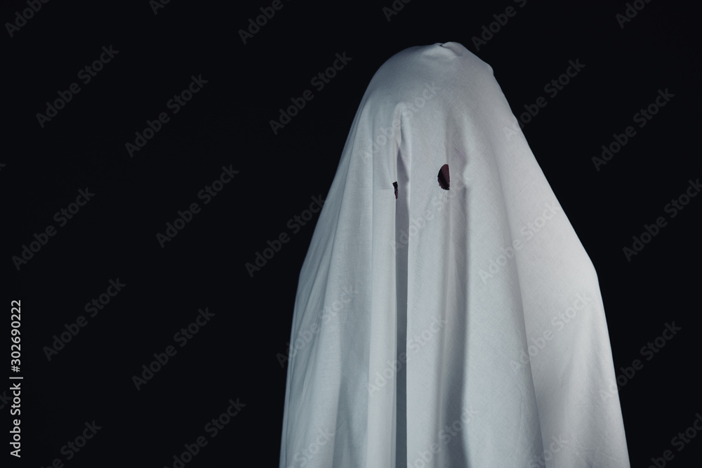 terrible ghost in white bedsheet isolated on black