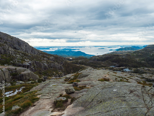 View on landscape with rock,blouders, stone and Lysefjord on hike to Preikestolen massive cliff famous Norway viewpoint Moody sky, autumn day. Nature and travel background, vacation and hiking holiday photo