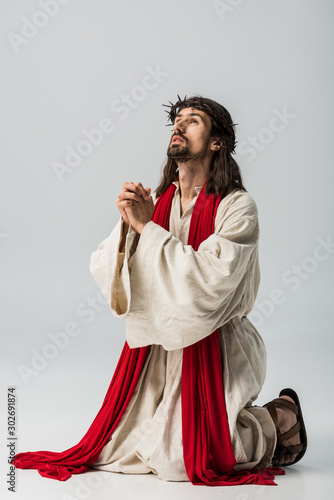 jesus in wreath praying on knees on grey