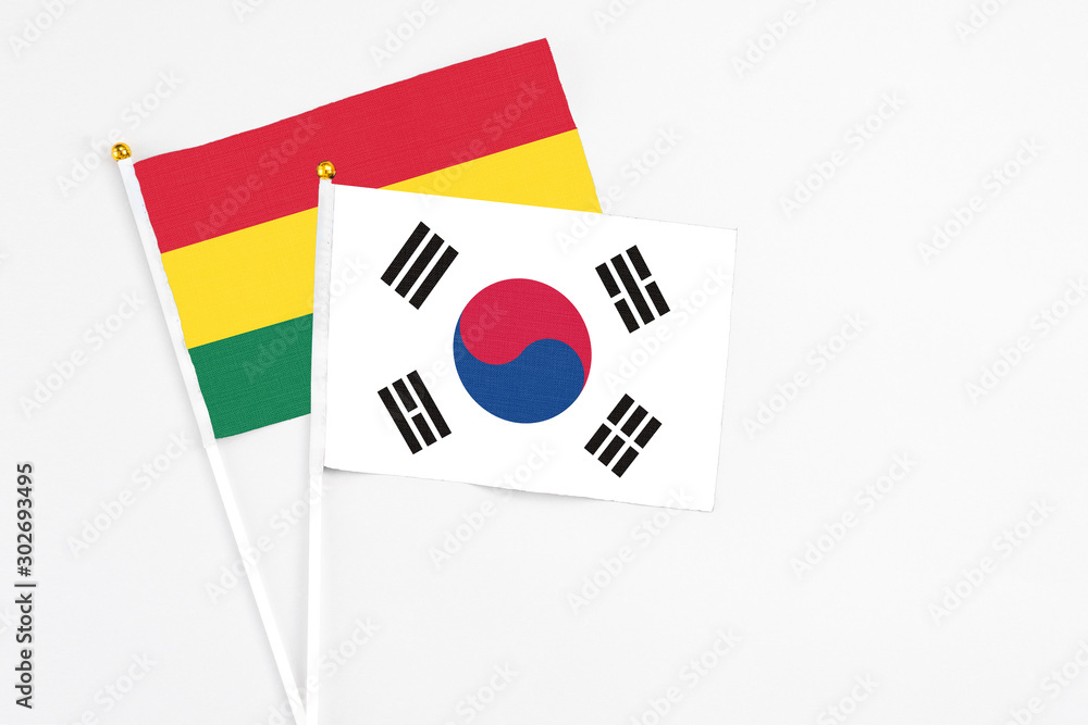 South Korea and Ghana stick flags on white background. High quality fabric, miniature national flag. Peaceful global concept.White floor for copy space.