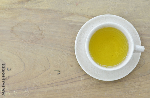 Fresh tea in white cup on wooden table photo