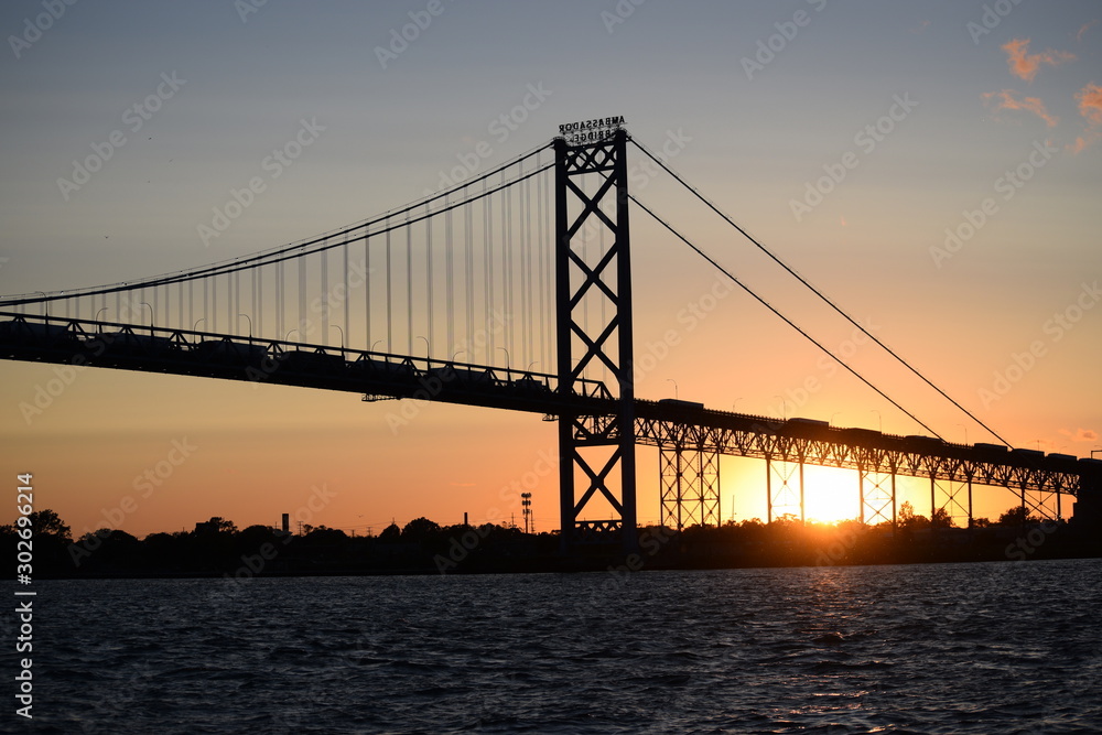 Ambassador Bridge between Detroit, Michigan and Windsor, Ontario. Sunset on the Detroit River with the silhouette of the bridge. Border crossing between the US and Canada