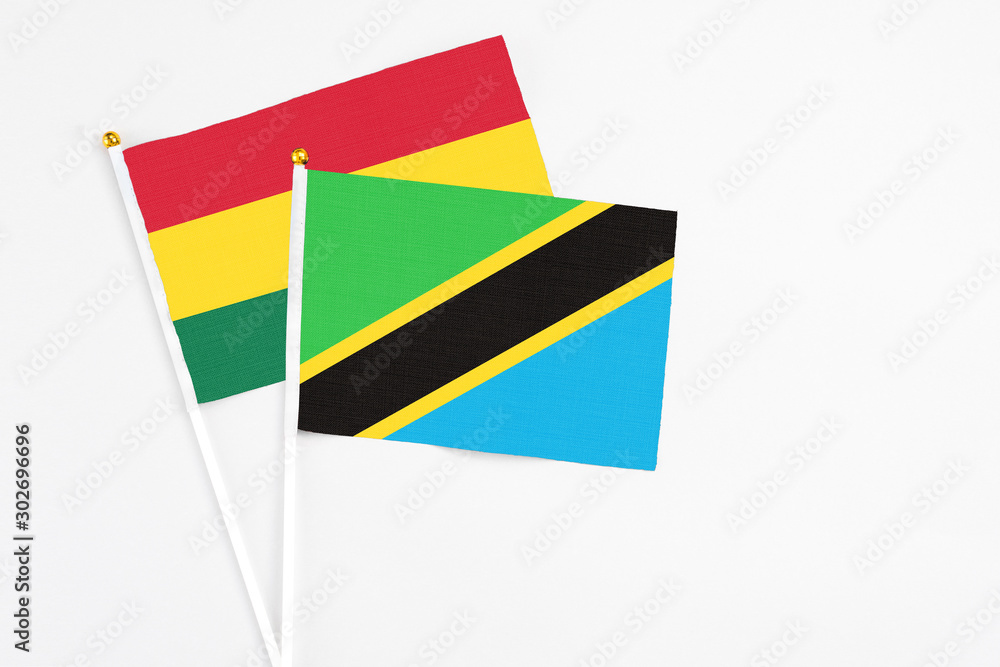 Fototapeta premium Tanzania and Ghana stick flags on white background. High quality fabric, miniature national flag. Peaceful global concept.White floor for copy space.
