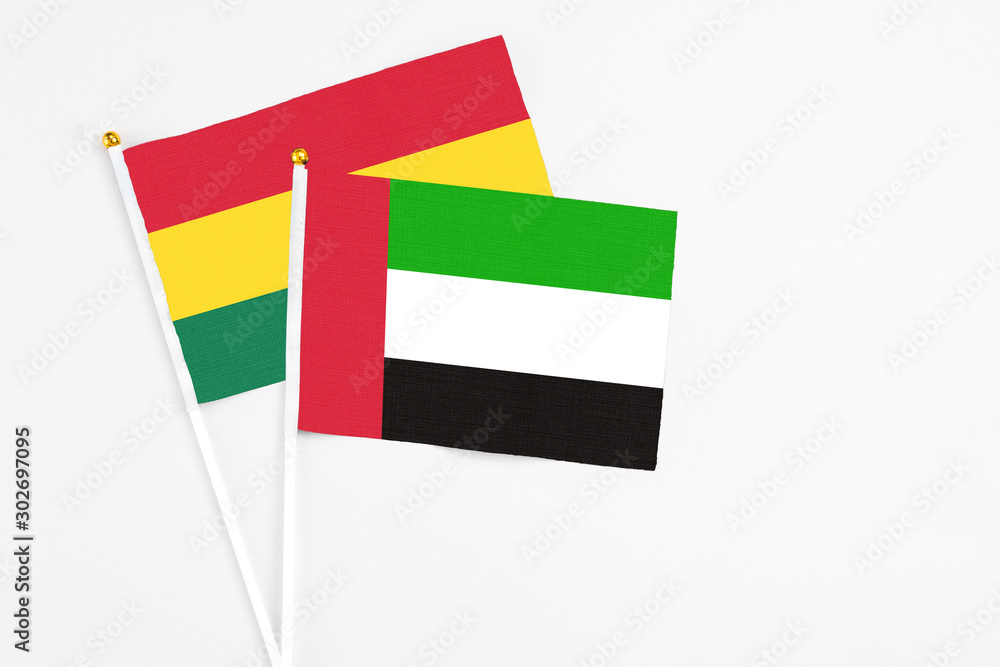 United Arab Emirates and Ghana stick flags on white background. High quality fabric, miniature national flag. Peaceful global concept.White floor for copy space. United Arab Emirates and Ghana stick flags on white background. High quality fabric, miniature national flag. Peaceful global concept.White floor for copy space.