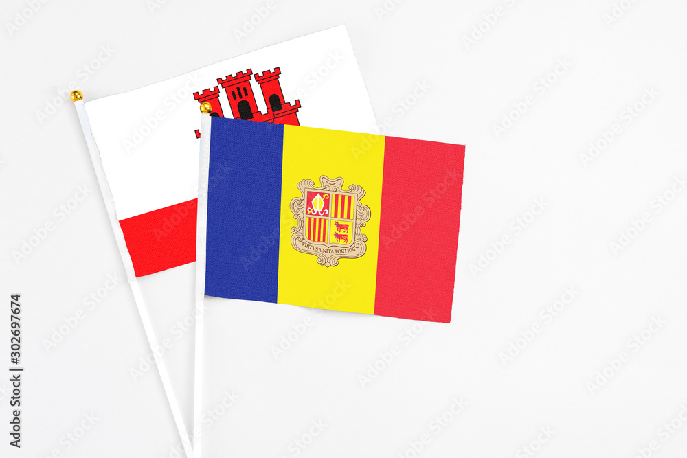 Andorra and Gibraltar stick flags on white background. High quality fabric, miniature national flag. Peaceful global concept.White floor for copy space. Andorra and Gibraltar stick flags on white background. High quality fabric, miniature national flag. Peaceful global concept.White floor for copy space.