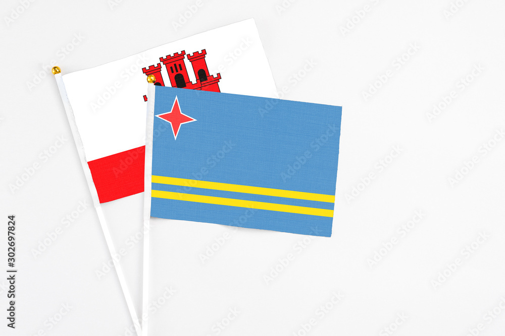 Aruba and Gibraltar stick flags on white background. High quality fabric, miniature national flag. Peaceful global concept.White floor for copy space. Aruba and Gibraltar stick flags on white background. High quality fabric, miniature national flag. Peaceful global concept.White floor for copy space.