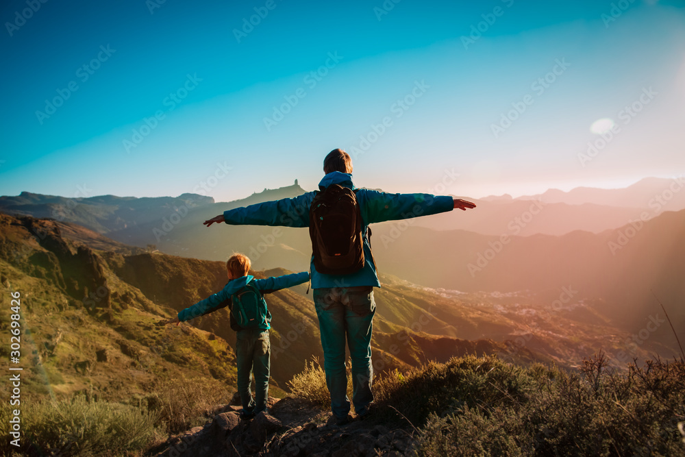 Fototapeta premium Happy father and son hiking at sunset mountains