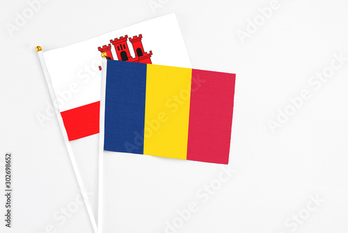 Chad and Gibraltar stick flags on white background. High quality fabric, miniature national flag. Peaceful global concept.White floor for copy space. photo