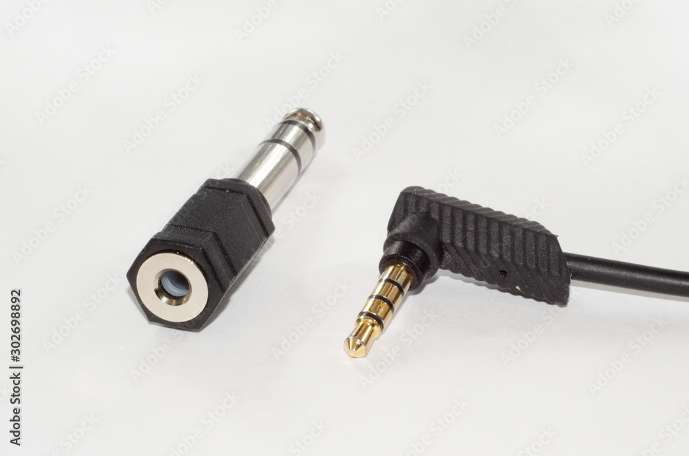 6.35 mm male to 3,5 mm female jack adapter and mii jack audio cable. Isolated on white. 6.35 mm male to 3,5 mm female jack adapter and mii jack audio cable. Isolated on white.