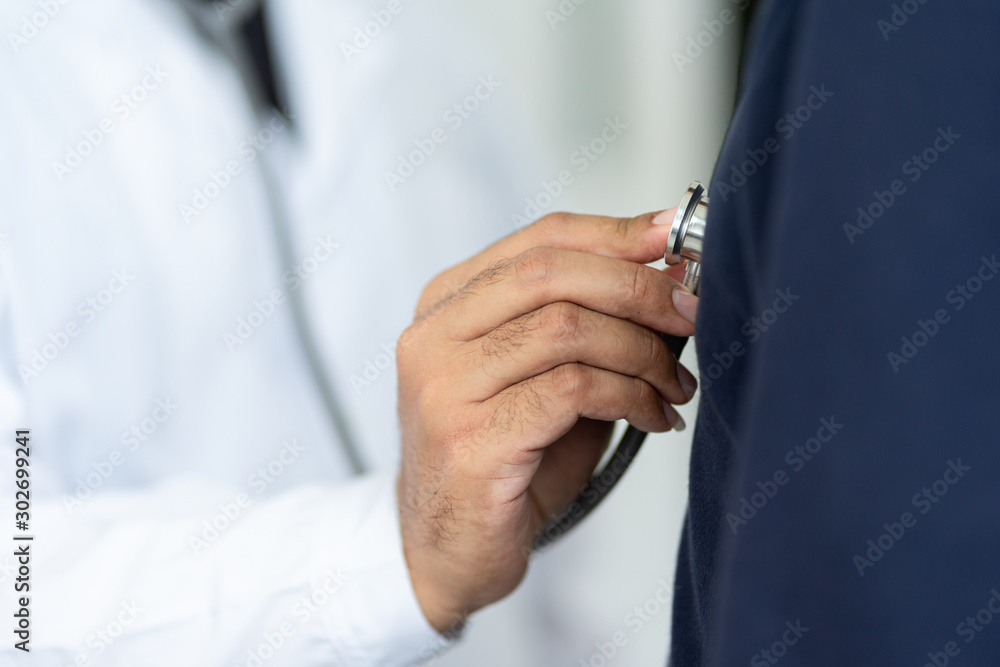Close up of a doctor holding stethoscope checking patient heartbeat. Close up of a doctor holding stethoscope checking patient heartbeat.