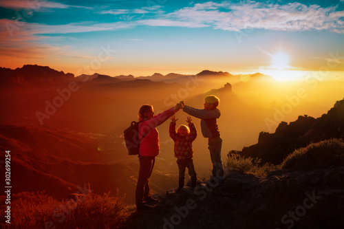 mother with kids -son and daughter - enjoy travel in sunset mountains