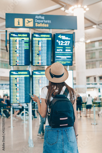 tourist with a backpack looks at the scoreboard at the airport