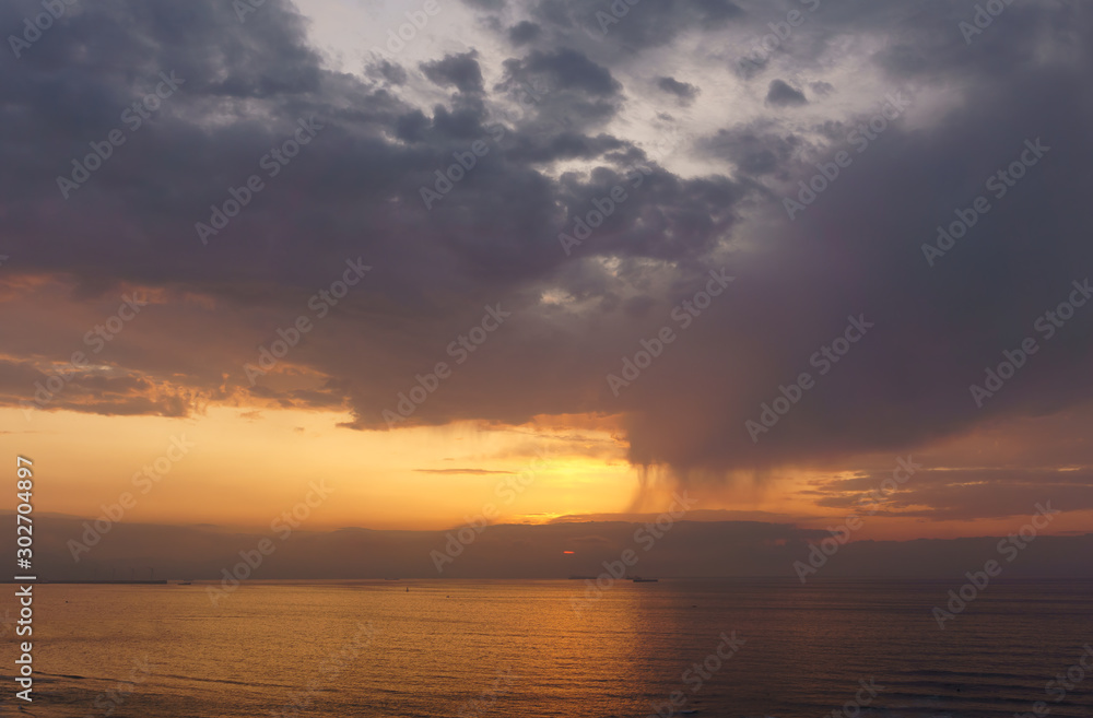 beautiful sunset over the sea with rain showers