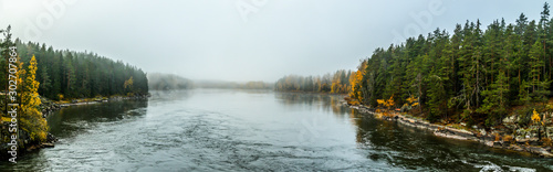 Beautiful autumn landscape of Kymijoki river waters in fog. Panoramic view. Finland, Kymenlaakso, Kotka. photo