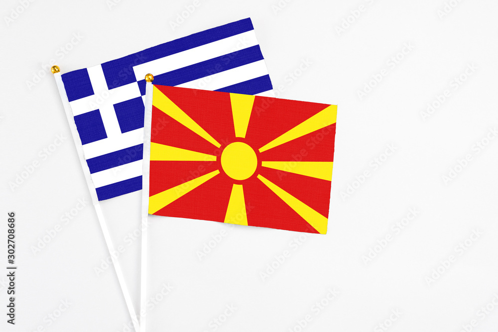 Macedonia and Greece stick flags on white background. High quality fabric, miniature national flag. Peaceful global concept.White floor for copy space.