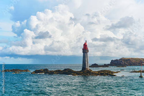 Leuchtturm im Meer vor St. Malo in der Bretagne mit imposanten Wolken photo