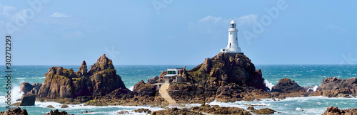 La Corbiere Leuchtturm auf Jersey bei Flut und Sonnenschein mit Wellengang photo