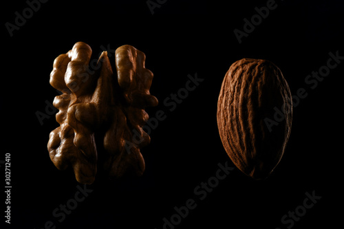 Walnut and almond macro shots of nuts on black background.