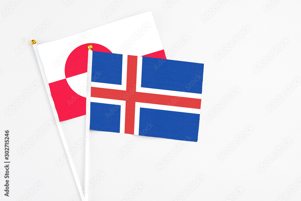 Iceland and Greenland stick flags on white background. High quality fabric, miniature national flag. Peaceful global concept.White floor for copy space.