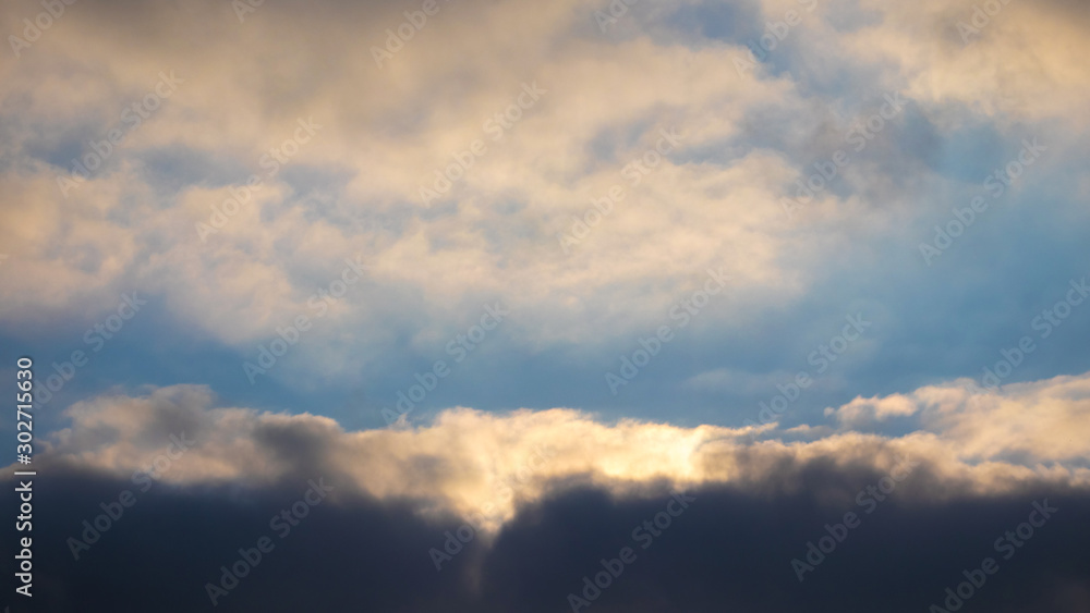 Dark dramatic sky with reflections of sun on clouds_
