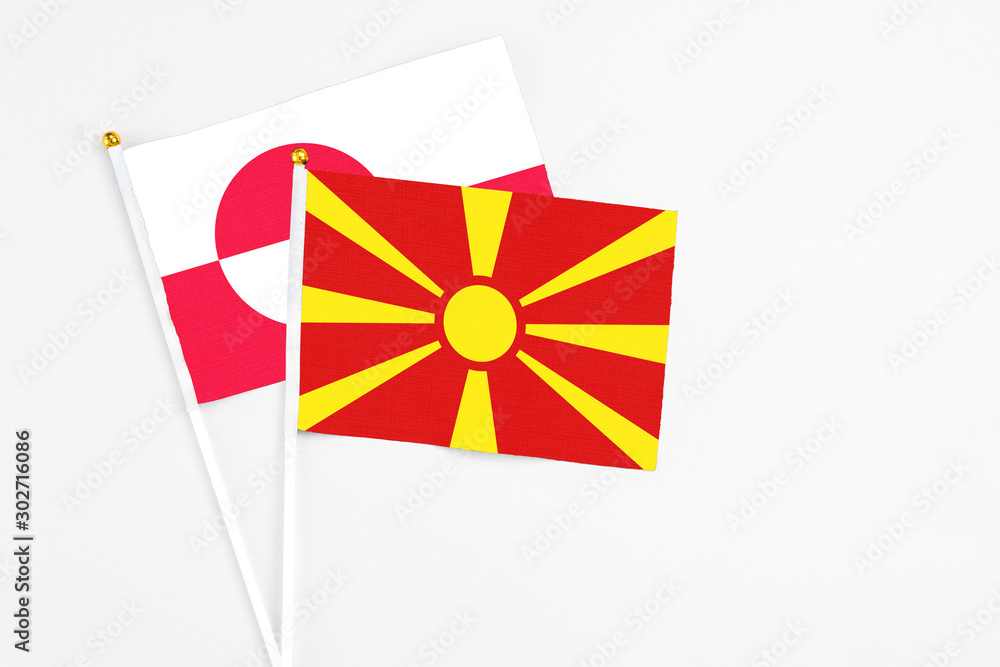 Macedonia and Greenland stick flags on white background. High quality fabric, miniature national flag. Peaceful global concept.White floor for copy space.