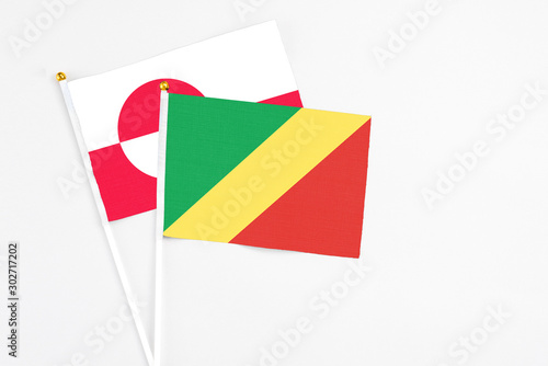 Republic Of The Congo and Greenland stick flags on white background. High quality fabric, miniature national flag. Peaceful global concept.White floor for copy space.