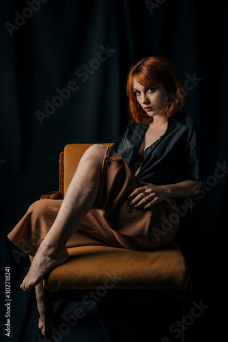 Young woman in dress sitting on a chair